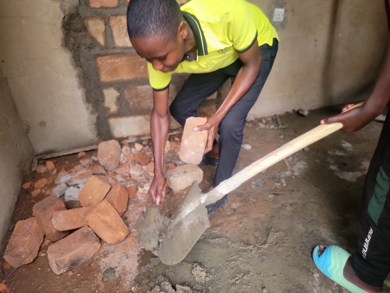 Students mixing mortar during building and construction practical training