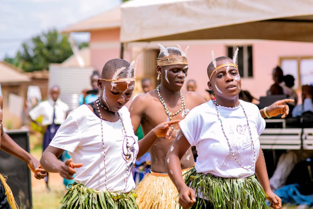 Students in cultural dance costume with feather headdresses